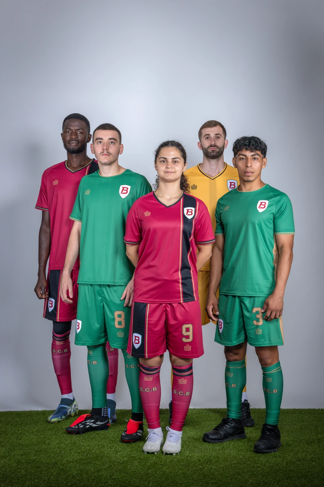 Five SC Brooklyn players modeling the crimson, green and gold Admiral collection